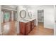 Bathroom showcasing a double vanity with oval mirrors and a view into the bedroom and walk-in closet at 1781 Point Pleasant Se, Smyrna, GA 30080