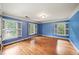 Spacious bedroom with hardwood floors, white trim, three windows, and painted blue walls at 1781 Point Pleasant Se, Smyrna, GA 30080