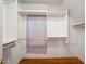 Organized walk-in closet featuring white shelving, wooden clothing rods, and hardwood floors at 1781 Point Pleasant Se, Smyrna, GA 30080