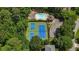 Overhead view of community tennis and basketball courts surrounded by green trees at 1781 Point Pleasant Se, Smyrna, GA 30080