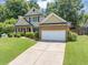 Traditional style home with a well-manicured front yard and brick accents and an attached garage at 10535 Willow Meadow Cir, Alpharetta, GA 30022
