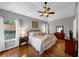 Comfortable main bedroom with ceiling fan, windows offering natural light, and beautiful hardwood flooring at 10535 Willow Meadow Cir, Alpharetta, GA 30022