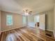 A cozy bedroom with wood floors, a ceiling fan, and an attached bathroom with good natural light at 180 Bishop Nw Rd, Cartersville, GA 30121