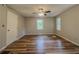 A spacious bedroom featuring wood flooring, dual windows, and a ceiling fan with light fixture at 180 Bishop Nw Rd, Cartersville, GA 30121