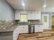 Updated kitchen featuring stainless steel dishwasher, granite countertops, and mosaic backsplash at 180 Bishop Nw Rd, Cartersville, GA 30121