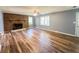 Bright living room with a brick fireplace, ceiling fan, and new hardwood flooring at 180 Bishop Nw Rd, Cartersville, GA 30121