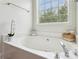 Bright bathroom featuring a large soaking tub under a window, complete with stylish fixtures and decor at 2140 Hurt Sw Rd, Marietta, GA 30008