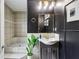 Modern bathroom featuring a walk-in shower, dark walls, tiled walls, and a stylish vanity with gold fixtures at 2140 Hurt Sw Rd, Marietta, GA 30008