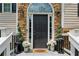 Elegant front door with decorative stone surround and potted plants at 2140 Hurt Sw Rd, Marietta, GA 30008