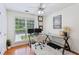 Home office with large window, hardwood floors, ceiling fan, and desk set for two monitors at 2140 Hurt Sw Rd, Marietta, GA 30008