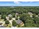 Wide aerial view of a residential neighborhood with lush trees and a lake in the background at 2832 Windrush Dr, Buford, GA 30518