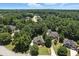 Aerial view of a home nestled in a wooded neighborhood showcasing mature trees and well-manicured lawns at 2832 Windrush Dr, Buford, GA 30518