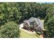 Aerial view of a brick two-story home, showcasing the manicured lawn and driveway at 2832 Windrush Dr, Buford, GA 30518