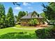 Expansive backyard view features a wooden deck, lush lawn, mature trees, and landscaped stone accents at 2832 Windrush Dr, Buford, GA 30518