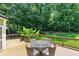 Wooden deck with wrought-iron table and four chairs overlooking a lush green, tree-lined backyard at 2832 Windrush Dr, Buford, GA 30518