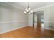 Spacious dining room with hardwood floors, wainscoting, and a modern chandelier at 2832 Windrush Dr, Buford, GA 30518
