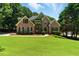 Charming two-story brick home with a well-manicured lawn and lush landscaping at 2832 Windrush Dr, Buford, GA 30518