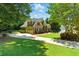 Well-maintained exterior with verdant lawn, long driveway, and mature trees at 2832 Windrush Dr, Buford, GA 30518