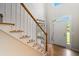 Bright foyer with hardwood floors, staircase, and entry door with sidelights and transom window at 2832 Windrush Dr, Buford, GA 30518