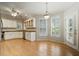 Eat-in kitchen featuring white cabinets, stainless steel appliances, and hardwood floors at 2832 Windrush Dr, Buford, GA 30518