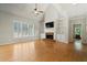 Cozy living room with a fireplace, built-in shelving, and hardwood flooring at 2832 Windrush Dr, Buford, GA 30518