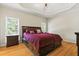 Spacious main bedroom featuring a tray ceiling, wood floors, and large windows at 2832 Windrush Dr, Buford, GA 30518