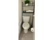 Compact bathroom featuring a toilet with shelving above, tiled floors, and essential fixtures at 300 Peachtree Ne St # 11I, Atlanta, GA 30308