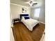Well-lit bedroom with hardwood floors, ceiling fan, and a comfortable bed with white linens and blue accents at 300 Peachtree Ne St # 11I, Atlanta, GA 30308