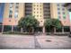 Facade of a multi-story building with trees flanking the entrance and a brick courtyard at 300 Peachtree Ne St # 11I, Atlanta, GA 30308