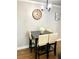 Dining area with a dark table, cream-colored chairs, a statement clock, and modern lighting at 300 Peachtree Ne St # 11I, Atlanta, GA 30308