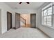 Bedroom showing access to hallway with staircase, neutral carpet, and a window with neighborhood views at 1273 Harvest Park Ln, Suwanee, GA 30024