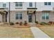 Close-up of a townhome featuring painted brick, a private entry, and manicured lawn at 1273 Harvest Park Ln, Suwanee, GA 30024