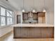 Kitchen features an island with white countertop, dark cabinets, and large window at 1273 Harvest Park Ln, Suwanee, GA 30024