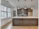 Kitchen island with dark cabinets, stone counters, and stainless appliances at 1273 Harvest Park Ln, Suwanee, GA 30024