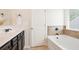 Bright bathroom featuring a soaking tub with tile surround and a vanity with a white countertop at 405 Blue Sky Circle Cir, Acworth, GA 30102