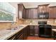 Granite countertops, stainless steel sink, and black appliances in the kitchen at 405 Blue Sky Circle Cir, Acworth, GA 30102