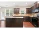 Well-lit kitchen features dark cabinets, granite counters, an island, and stainless steel appliances at 405 Blue Sky Circle Cir, Acworth, GA 30102