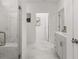 Long bathroom with marble tile, glass shower enclosure, and a sleek vanity with modern fixtures at 98 Keown Loop, Sharpsburg, GA 30277