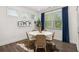 Bright dining room with a round table, woven chairs, and large windows with blue curtains at 98 Keown Loop, Sharpsburg, GA 30277