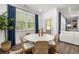 Bright dining room with natural light boasts woven chairs, a plant and blue curtains at 98 Keown Loop, Sharpsburg, GA 30277