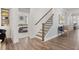 Wide hallway with hardwood floors, bench, and views of the staircase and bedroom at 98 Keown Loop, Sharpsburg, GA 30277