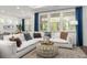 Bright open-concept living room with white sofa, large windows, and stylish decor at 98 Keown Loop, Sharpsburg, GA 30277