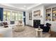 Cozy living room with fireplace, built-in bookshelves, and ample natural light at 98 Keown Loop, Sharpsburg, GA 30277