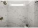 Close-up of shower boasts large marble-look tiles, sleek fixtures, and a built-in bench for added comfort at 98 Keown Loop, Sharpsburg, GA 30277