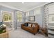 Comfortable sitting area boasts a cozy brown sofa, stylish curtains, and a bright view to a screened porch at 98 Keown Loop, Sharpsburg, GA 30277