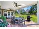 Covered backyard patio with dining table, seating, ceiling fans, and a grill overlooking the lawn at 105 Laurel Canyon Trl, Canton, GA 30114