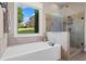 Bright bathroom featuring a large soaking tub and glass enclosed shower with backyard views at 105 Laurel Canyon Trl, Canton, GA 30114