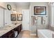Dual sink bathroom featuring granite countertops, bathtub, and two framed mirrors at 105 Laurel Canyon Trl, Canton, GA 30114
