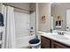 Bright bathroom featuring a shower-tub combo with white tile surround and dark brown vanity at 105 Laurel Canyon Trl, Canton, GA 30114
