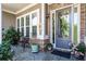 Charming front porch featuring stone accents, gray door, seating and flower pots at 105 Laurel Canyon Trl, Canton, GA 30114